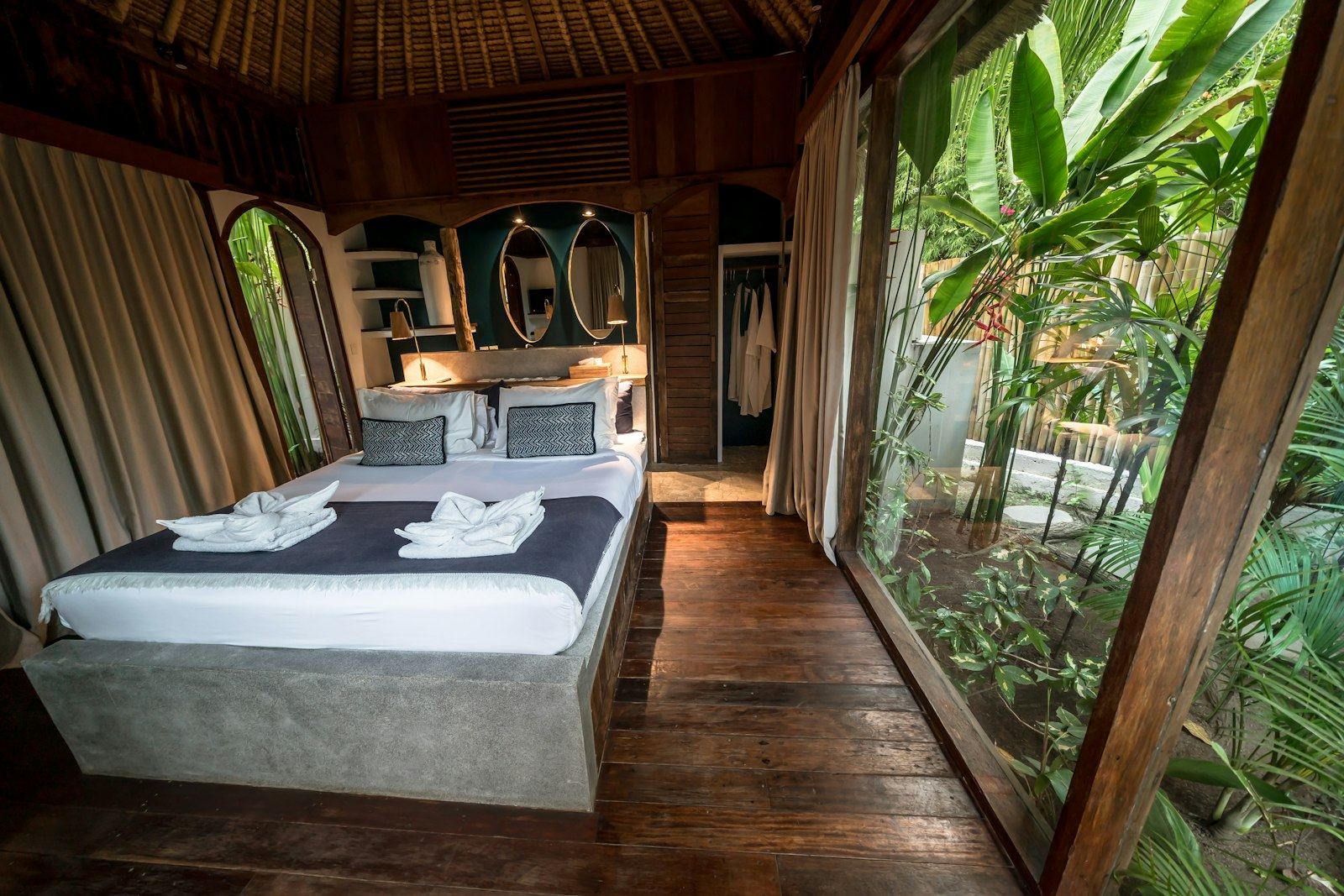Dormitorio de madera con ventanal abierto a la selva